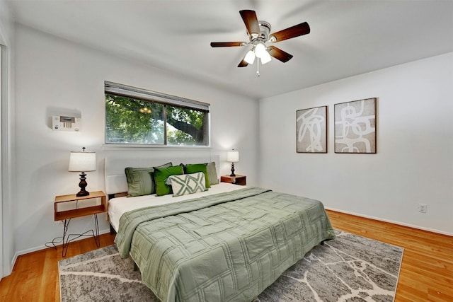 bedroom featuring light wood finished floors, baseboards, and a ceiling fan