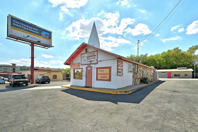 exterior space featuring uncovered parking and concrete block siding