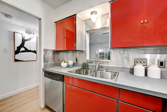 kitchen featuring red cabinets, a sink, and stainless steel dishwasher