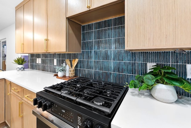 kitchen with gas stove, decorative backsplash, and light brown cabinets