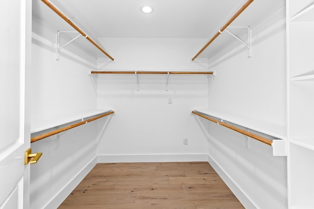 walk in closet with light hardwood / wood-style floors