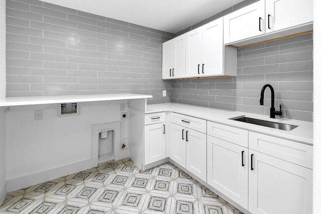 kitchen with sink, white cabinetry, and decorative backsplash