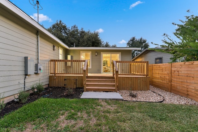 rear view of house featuring a yard and a deck