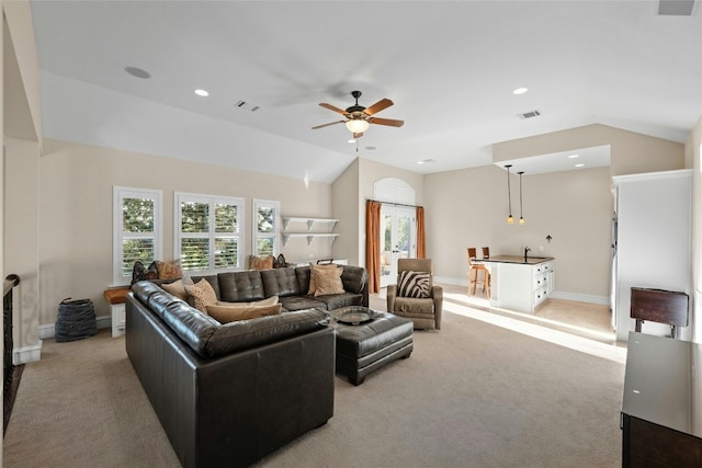 living area with lofted ceiling, baseboards, visible vents, and light colored carpet