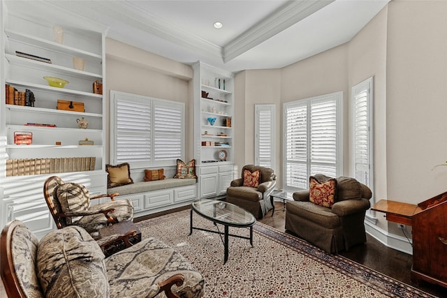 living area with built in features, a tray ceiling, recessed lighting, ornamental molding, and wood finished floors