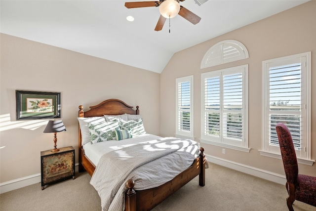 bedroom with light carpet, ceiling fan, baseboards, and vaulted ceiling