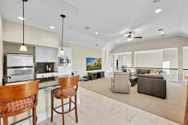 kitchen featuring a breakfast bar, white cabinets, open floor plan, appliances with stainless steel finishes, and dark countertops