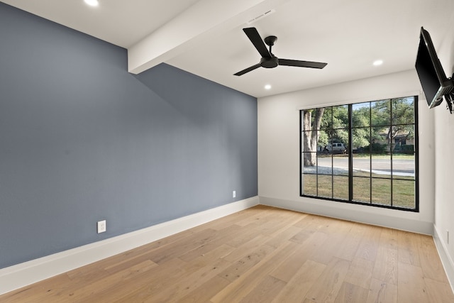 spare room with ceiling fan, light hardwood / wood-style flooring, and beamed ceiling