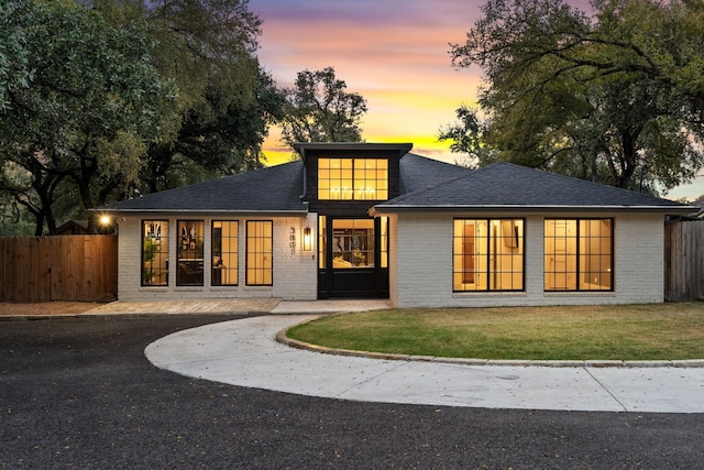 back house at dusk featuring a yard