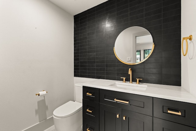 bathroom with vanity, toilet, tile walls, and tasteful backsplash