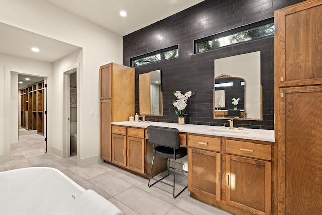 bathroom with tile patterned flooring, a washtub, toilet, and vanity