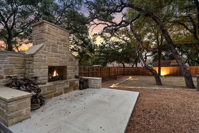 patio terrace at dusk with an outdoor stone fireplace