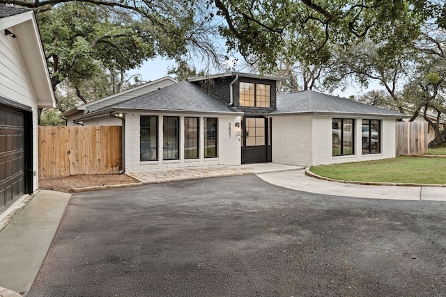 3801 Sierra Dr, Georgetown, TX 78628 - rear view of house featuring brick siding, roof with shingles, and driveway
