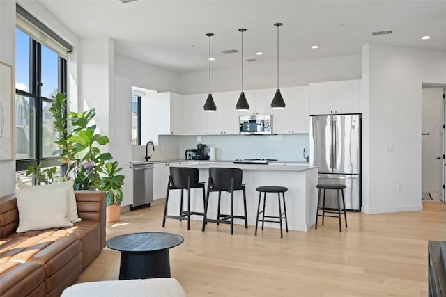 living room with light hardwood / wood-style floors and sink