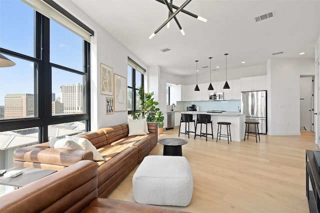 living room with light wood-type flooring and a notable chandelier