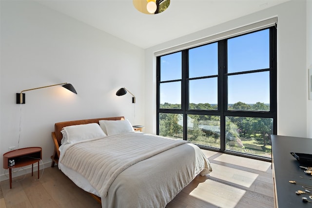 bedroom with hardwood / wood-style floors and multiple windows