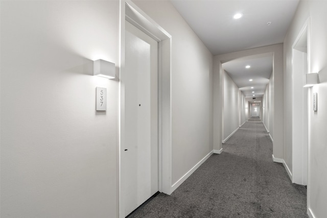 hallway with dark colored carpet