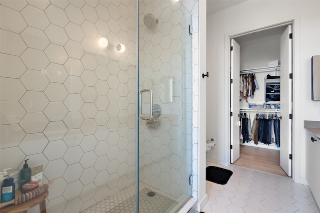 bathroom featuring tile patterned flooring, an enclosed shower, and tile walls