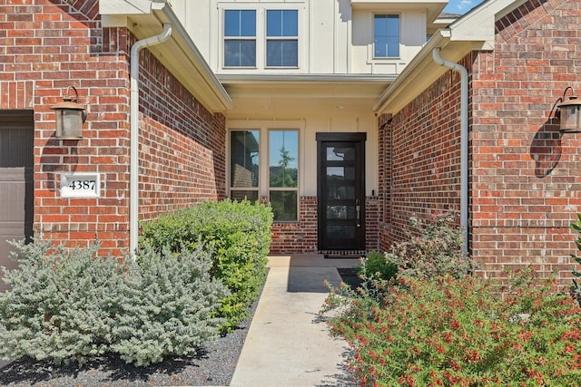 entrance to property with brick siding and an attached garage