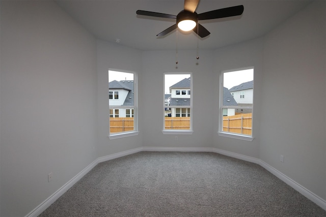 carpeted spare room featuring ceiling fan