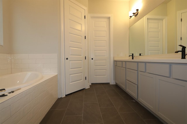 bathroom with tiled bath, tile patterned floors, and vanity