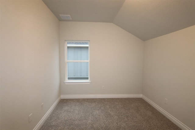 unfurnished room with lofted ceiling and carpet floors