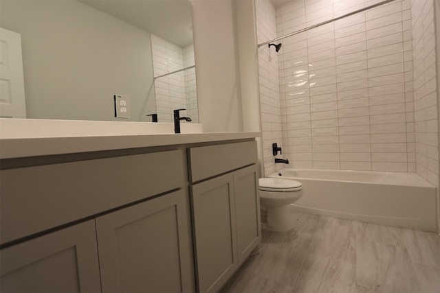 full bathroom with toilet, vanity, and tiled shower / bath