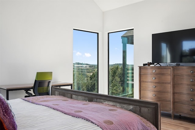 bedroom featuring lofted ceiling and light hardwood / wood-style floors