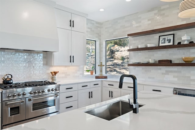 kitchen with double oven range, backsplash, custom exhaust hood, and white cabinets