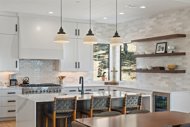 kitchen with beverage cooler, white cabinets, decorative light fixtures, and tasteful backsplash