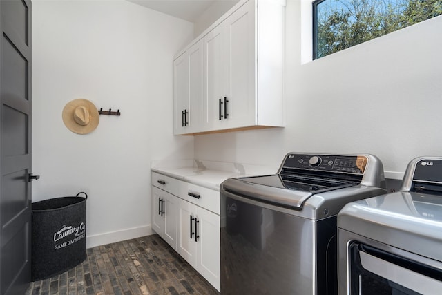 washroom featuring cabinets, dark hardwood / wood-style floors, and washer and clothes dryer