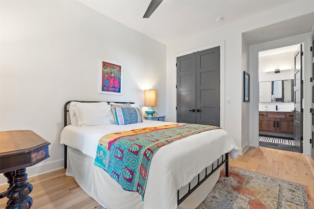 bedroom with ceiling fan, a closet, connected bathroom, and light hardwood / wood-style floors