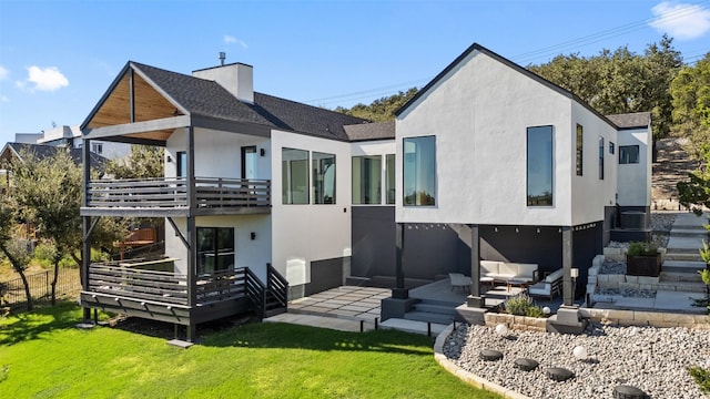 back of property with a yard, an outdoor living space, and a patio area