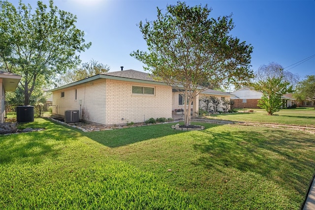 back of house with a lawn and central AC