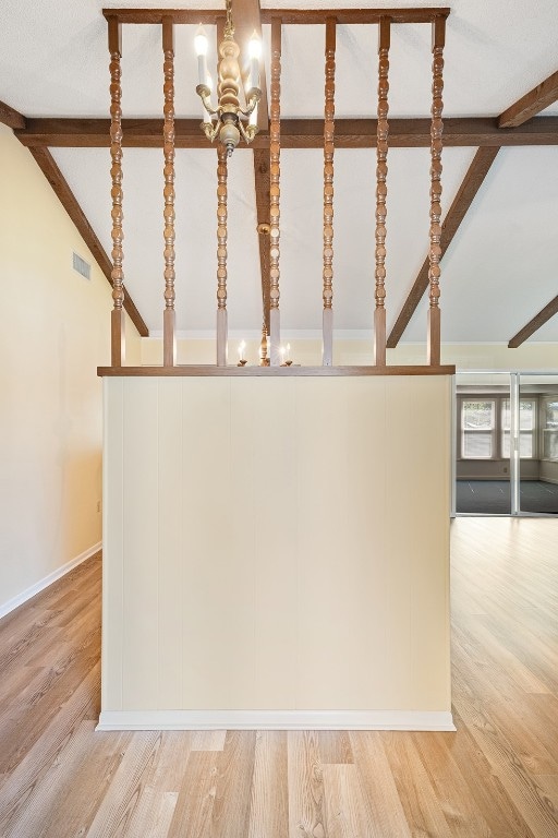 details featuring wood-type flooring, an inviting chandelier, and beam ceiling