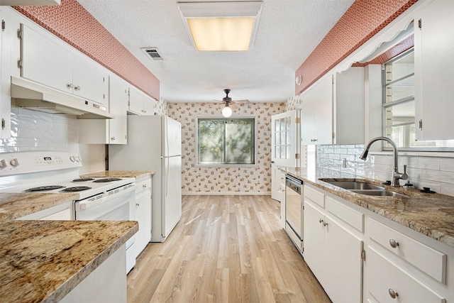 kitchen with a textured ceiling, sink, white cabinetry, light hardwood / wood-style flooring, and white appliances