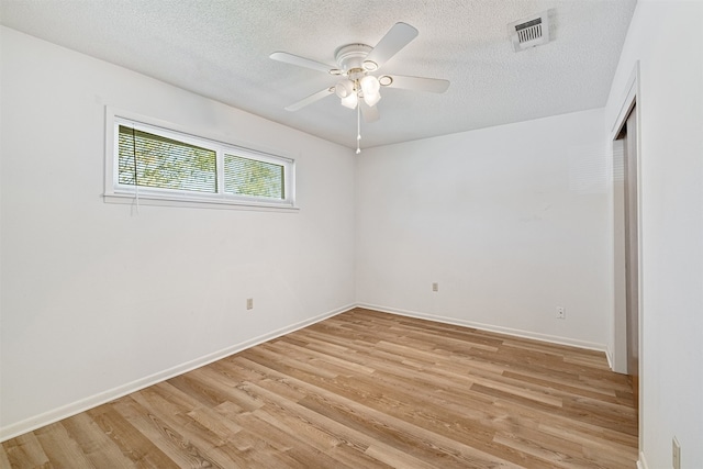 empty room featuring light hardwood / wood-style flooring, ceiling fan, and a textured ceiling