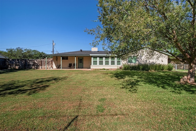 rear view of house with a lawn and a patio area