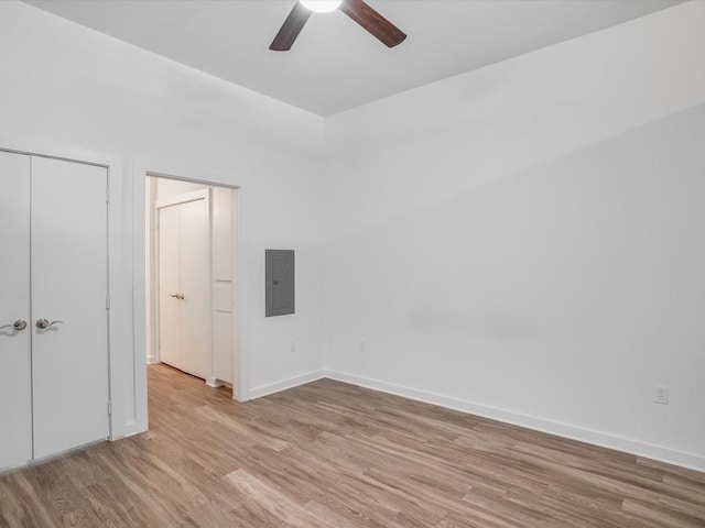 unfurnished bedroom with electric panel, ceiling fan, a closet, and light hardwood / wood-style floors