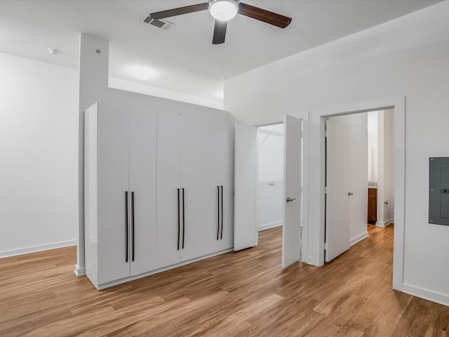 unfurnished bedroom featuring light wood-type flooring, electric panel, and ceiling fan