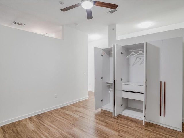 unfurnished bedroom with ceiling fan, light wood-type flooring, and a closet