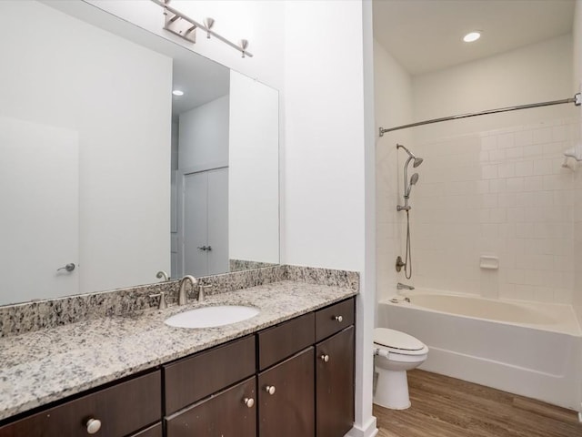 full bathroom featuring vanity, toilet, wood-type flooring, and tiled shower / bath combo