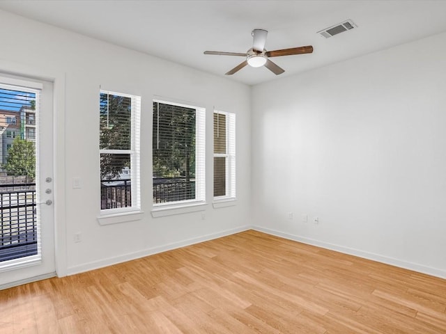 empty room with light hardwood / wood-style flooring, ceiling fan, and a healthy amount of sunlight