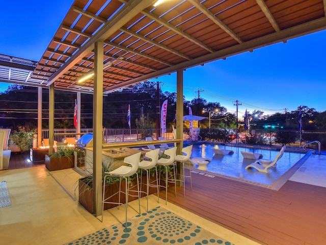 exterior space featuring a deck, a pergola, a jacuzzi, and exterior bar