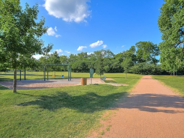 view of home's community featuring a playground and a yard