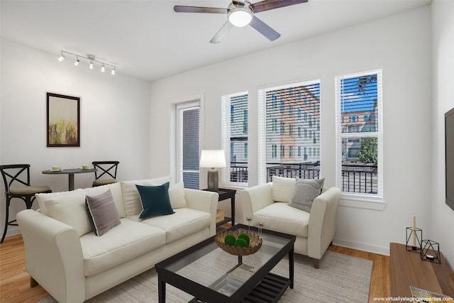 living room with light hardwood / wood-style flooring and ceiling fan