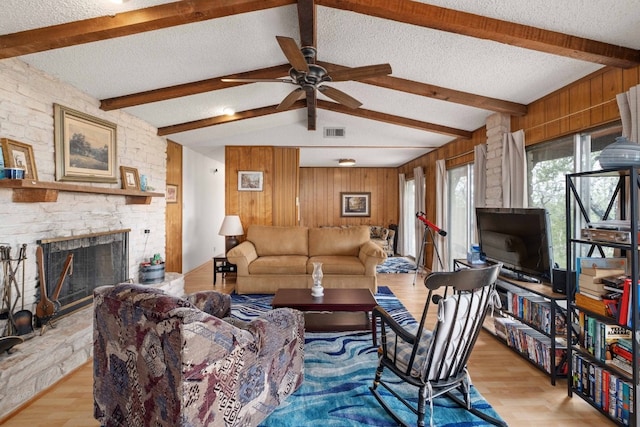 living room with light wood-type flooring, a fireplace, and lofted ceiling with beams