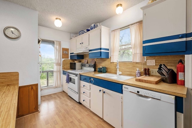 kitchen with light hardwood / wood-style floors, sink, white cabinets, decorative backsplash, and white appliances