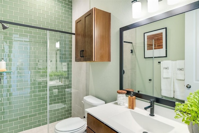 bathroom featuring vanity, toilet, and a shower with door