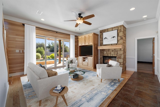 living room featuring a fireplace, ornamental molding, and ceiling fan